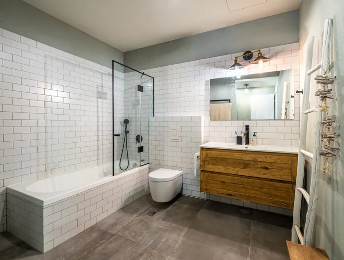 חדר רחצה עם אריחי סאבוויי לבנים, אמבטיה וארון עץ טבעי