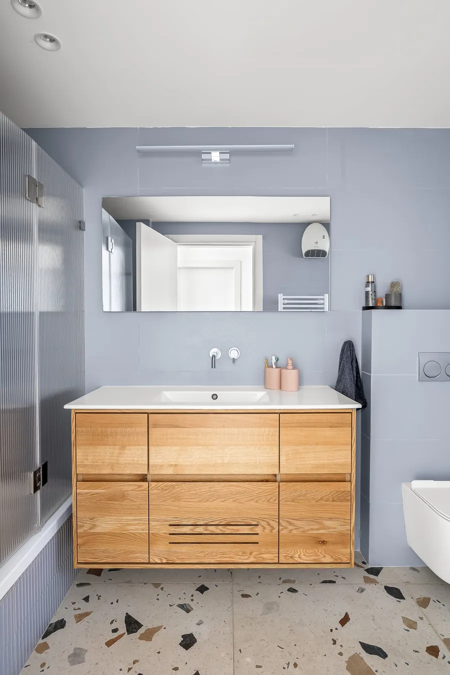 חדר רחצה עם ארון אלון, קירות בגוון כחול-אפור וריצוף טרצו