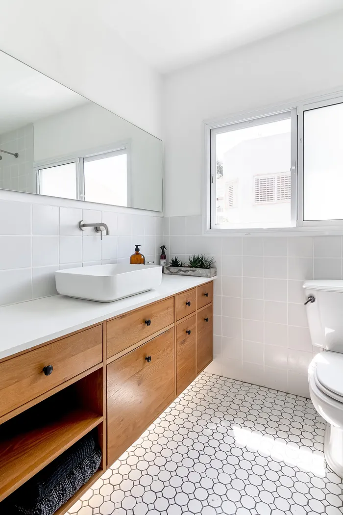 חדר רחצה עם ארון אלון, כיור מרובע וריצוף פני עגולים