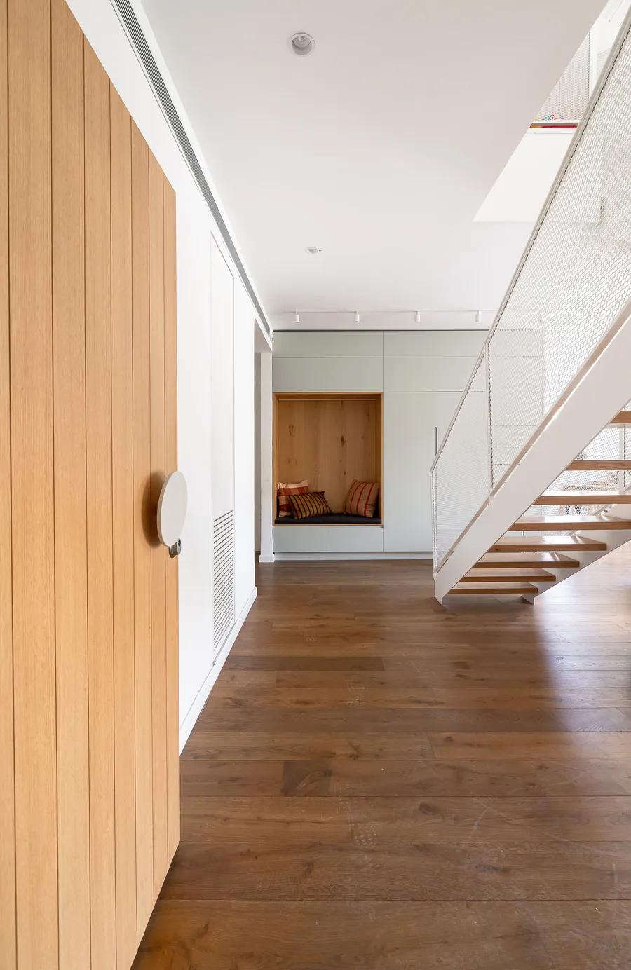 מסדרון כניסה עם דלת אלון, נישת ישיבה ומדרגות