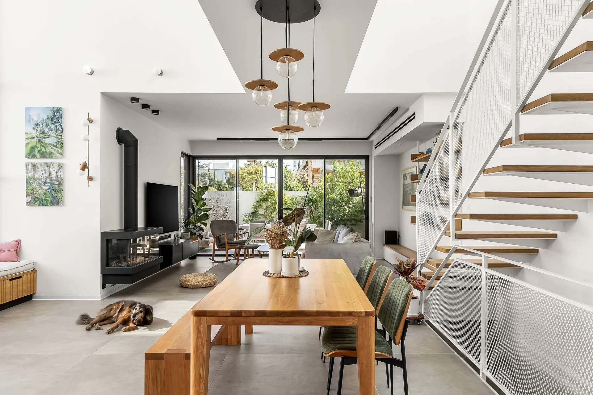 הבית בקריניצי — חלל מגורים פתוח עם גרם מדרגות ונוף לגינה