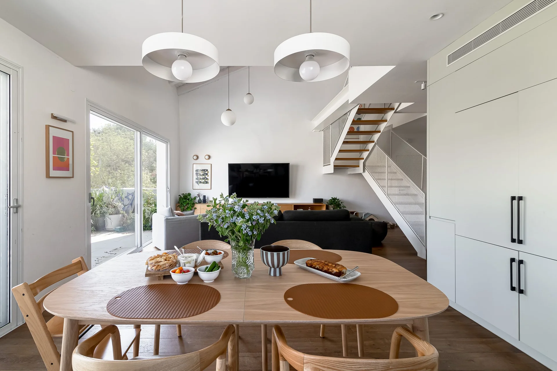 הבית ברמת חן — פינת אוכל מעץ אלון עם נוף לסלון וגרם מדרגות