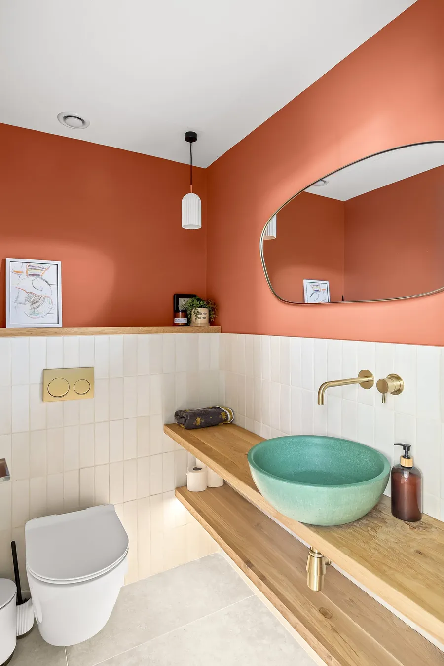 חדר שירותים עם קירות טרקוטה וכיור טורקיז