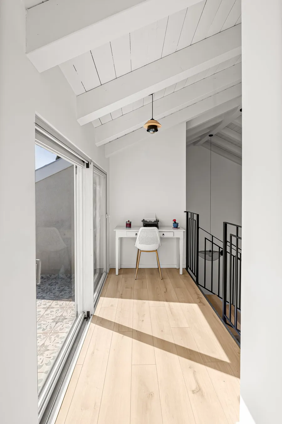 פינת עבודה בגלריה עם תקרת קורות ומרפסת